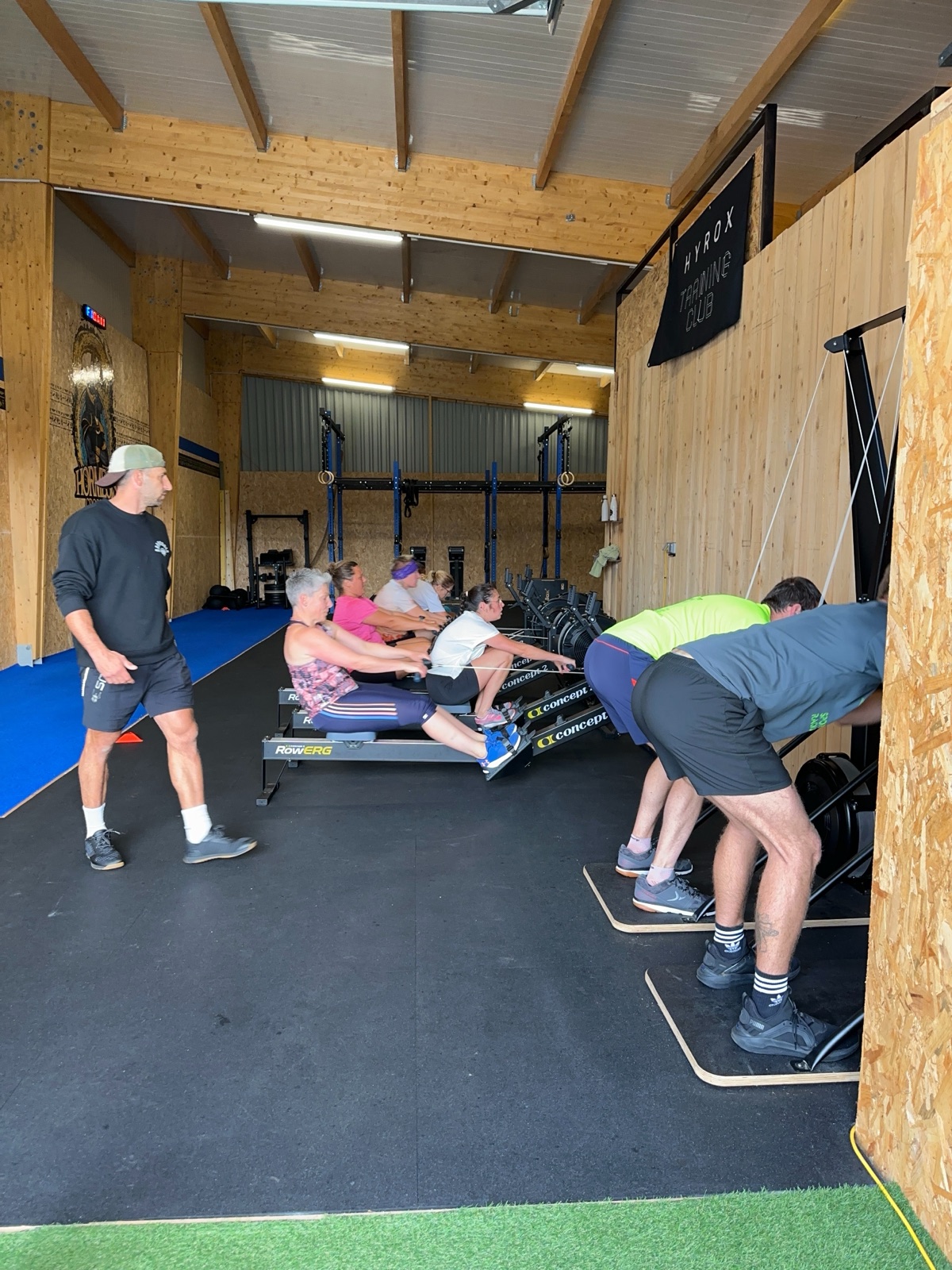 Un cours collectif aux rameurs et au SkiErg, encadre par un coach