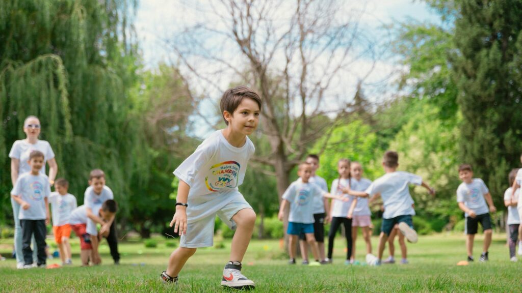 Des enfants courent et jouent dehors pendant une séance de sport encadrée